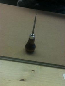 She uses an awl to pre-punch holes in each signature, allowing the needle to go through the paper more easily