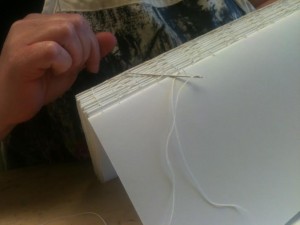 Heidi sews together signatures in her own book